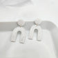 Dangle white arch earrings with silver shimmer