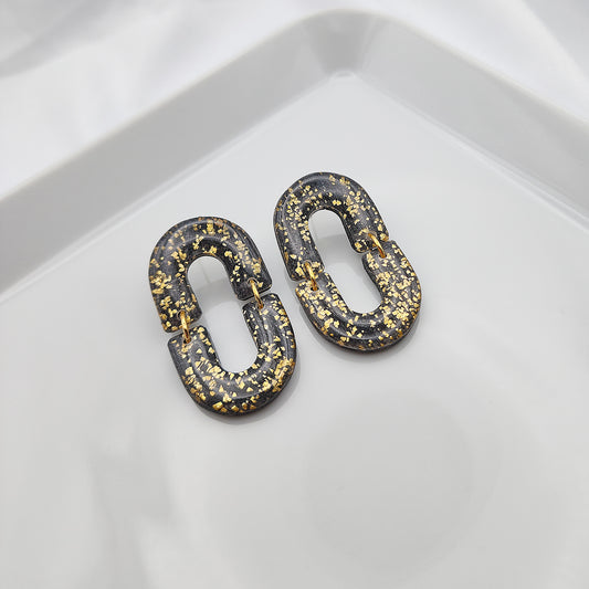 Oval dangle black earrings with gold shimmer