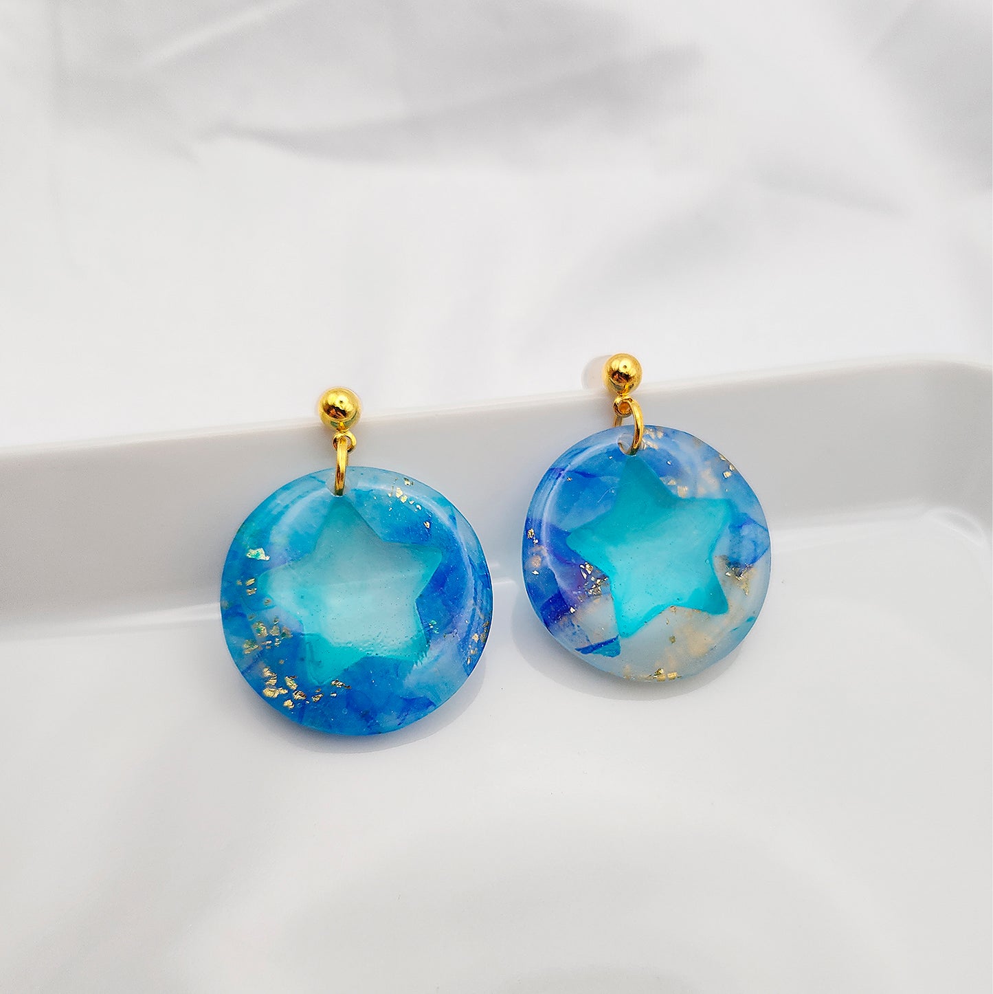 Blue earrings with a transparent middle in the form of a star