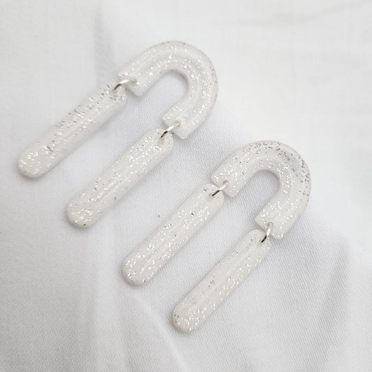 Dangle white arch earrings with silver shimmer