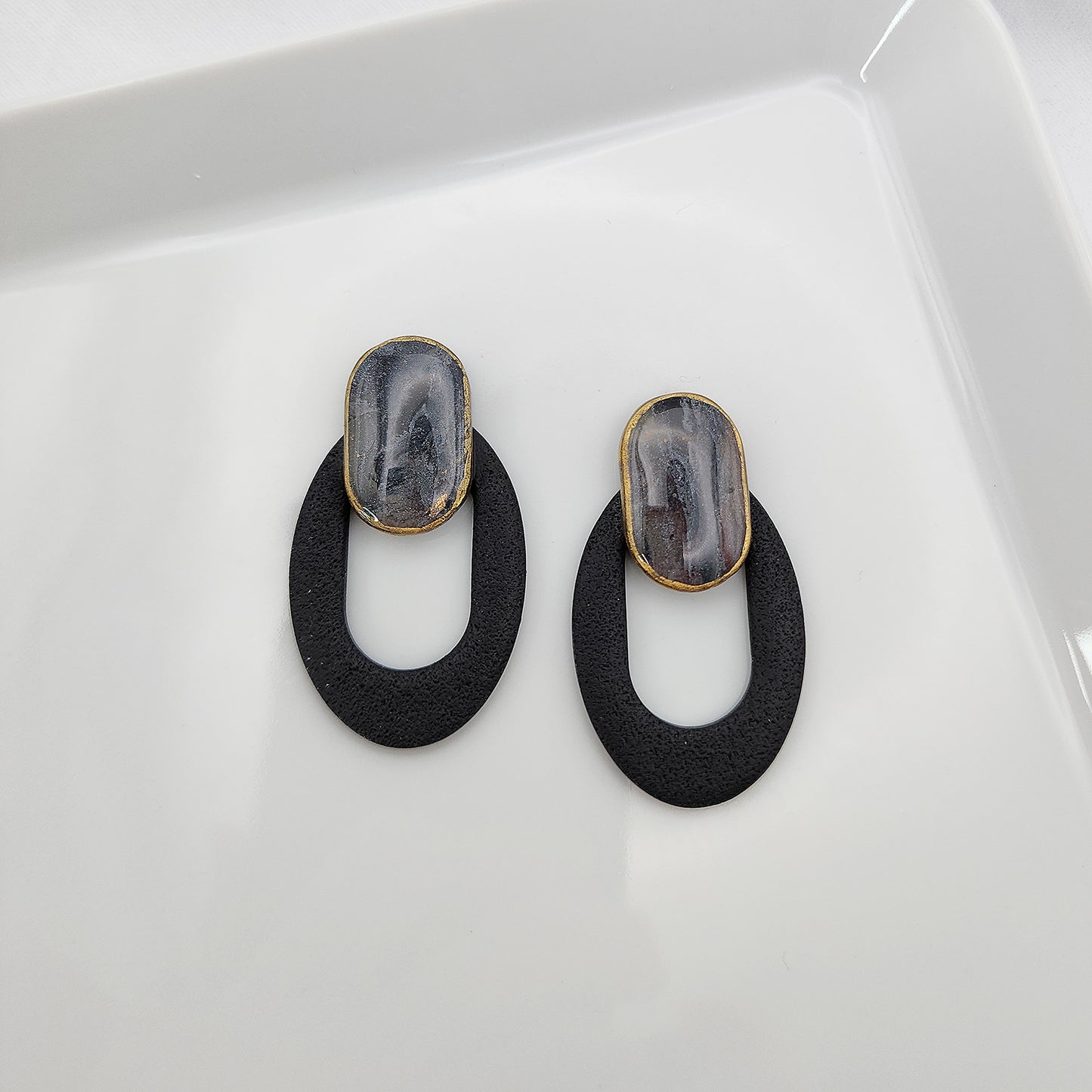 Black oval earrings with a clay stone stud