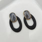 Black oval earrings with a clay stone stud