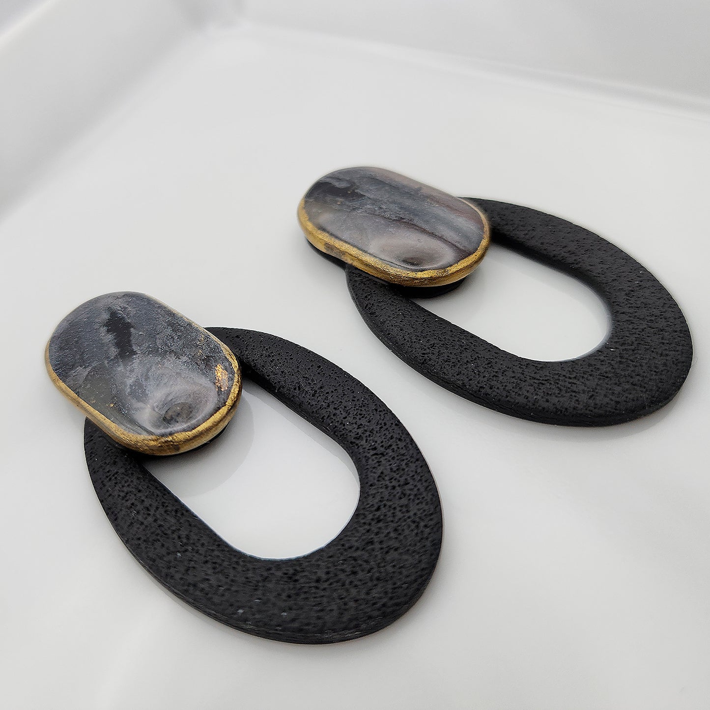 Black oval earrings with a clay stone stud