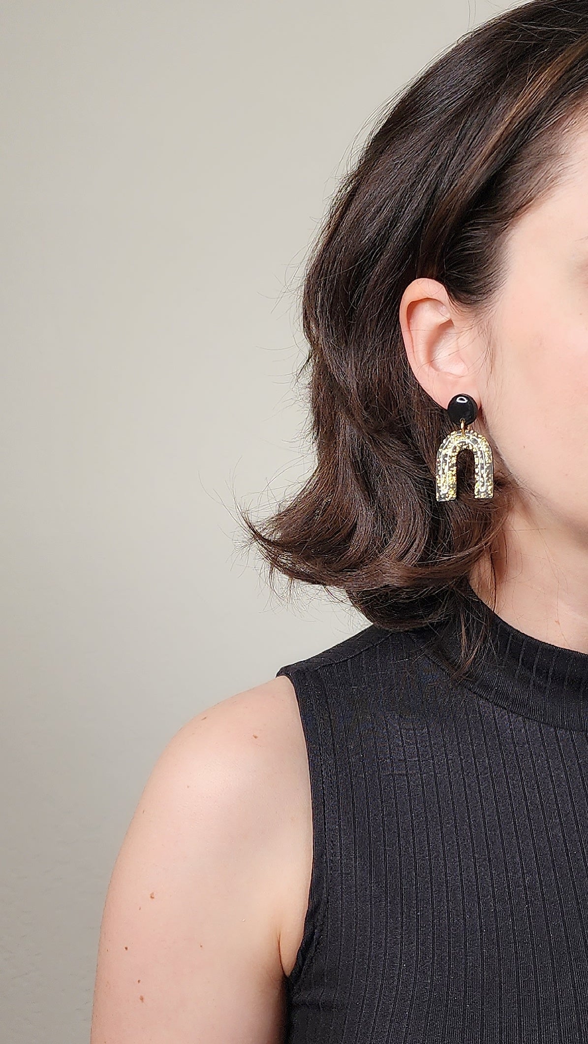 Black arch dangle earrings with gold shimmer